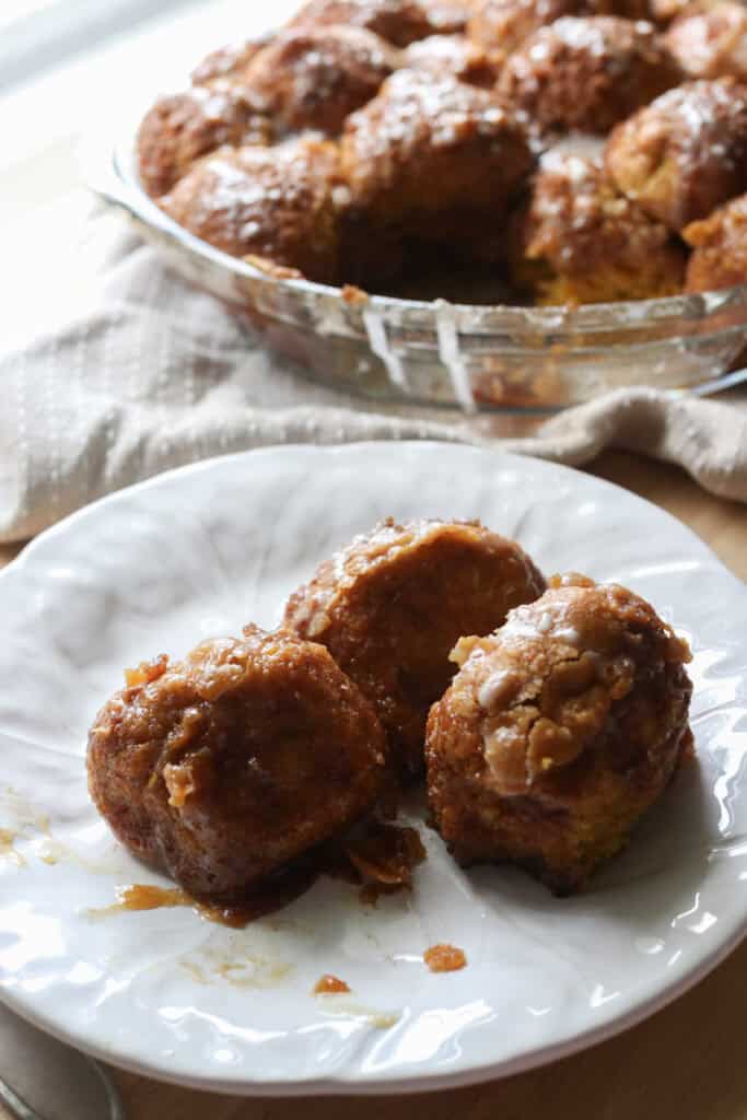 three pieces of fresh milled pumpkin monkey bread on a white plate