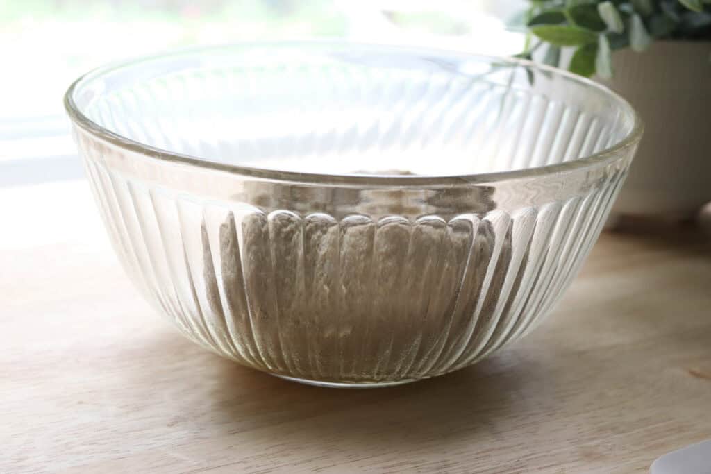 the dough for freshly milled parmesan pesto star bread in a glass bowl