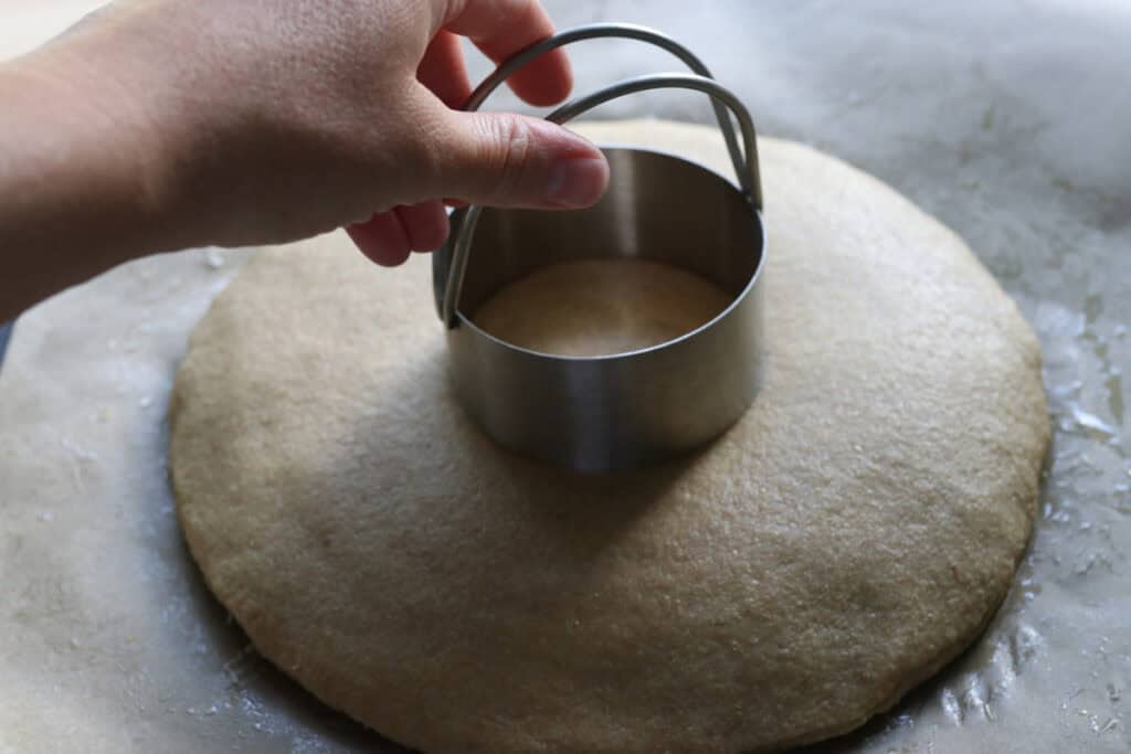 pressing into the dough for freshly milled parmesan pesto star bread with a biscuit cutter to make an indention 