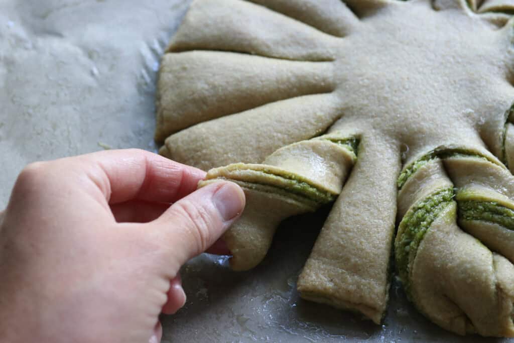 twisting the ends of freshly milled parmesan pesto star bread