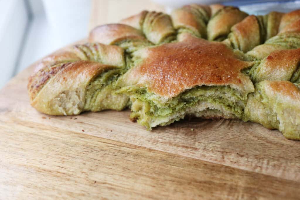 freshly milled parmesan pesto bread that has been cut in the center and has layers of pesto and cheese