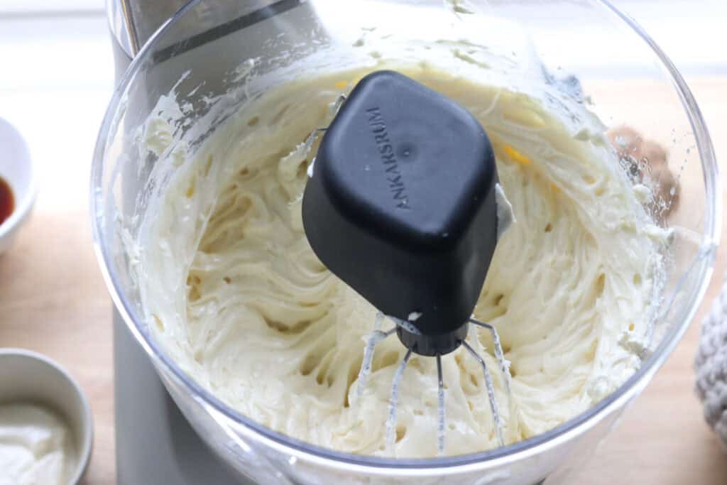 whipped cream cheese in a mixing bowl to make the filling for pumpkin cheesecake bars with fresh milled crust