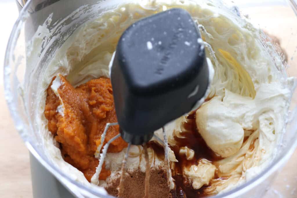 pumpkin puree, pumpkin spice and cream cheese in a mixing bowl to make pumpkin cheesecake bars with fresh milled crust