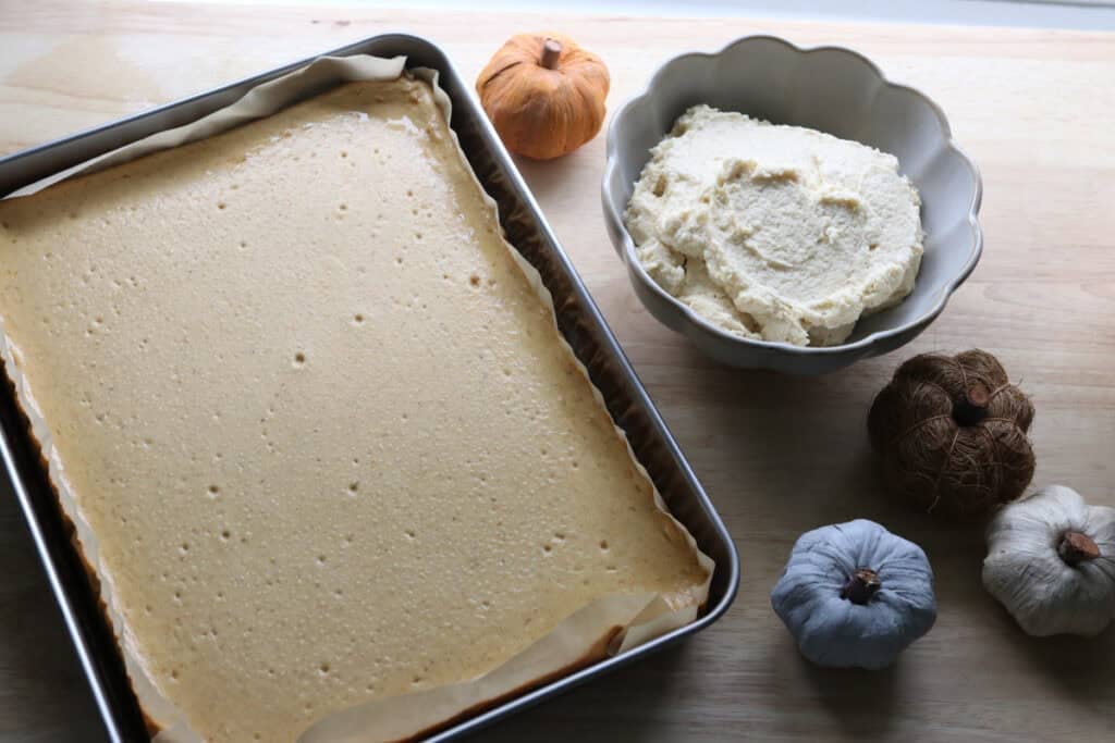 pumpkin cheesecake bars with fresh milled crust and spiced frosting in a bowl