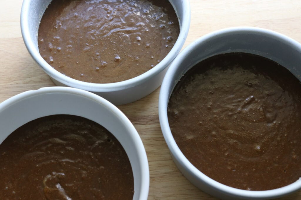 fresh milled gingerbread cake batter divided between 3 cake pans