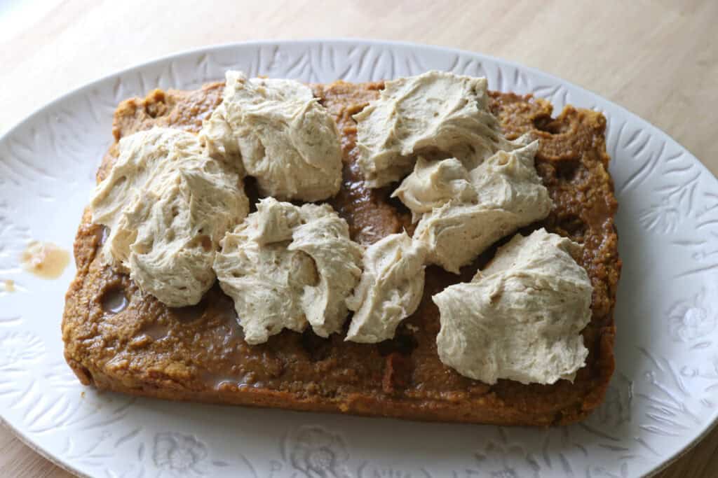 spiced espresso cream cheese frosting being spread onto the freshly milled pumpkin spice latte cake