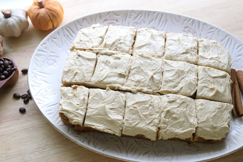 sliced Freshly Milled Pumpkin Spice Latte Cake with Frosting and mini pumpkins