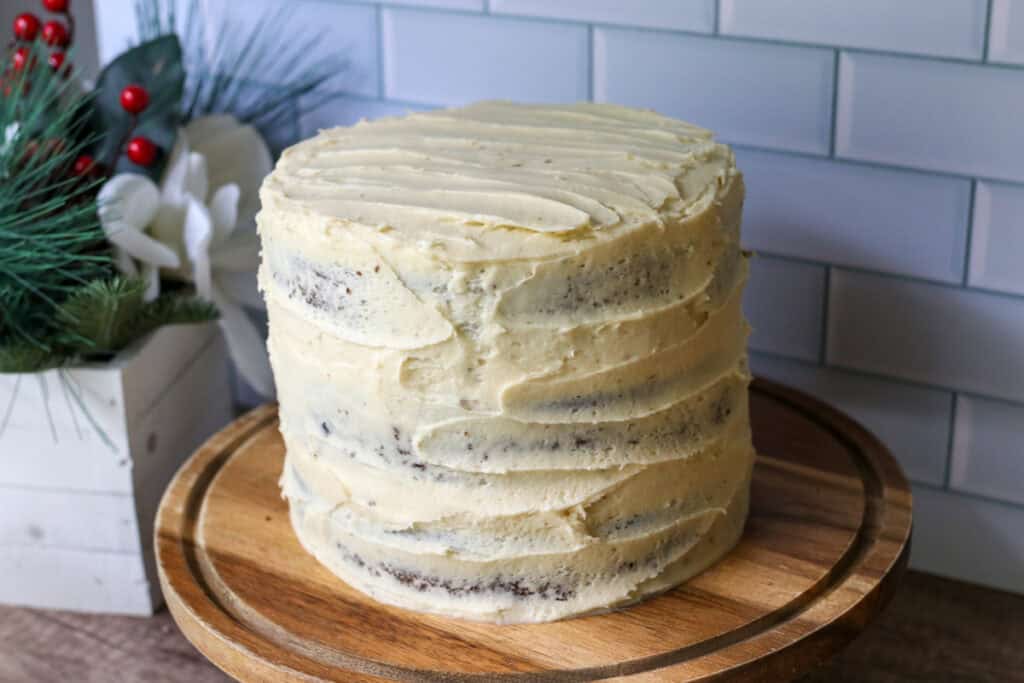 fresh milled gingerbread cake with cream cheese icing on a wooden cake stand