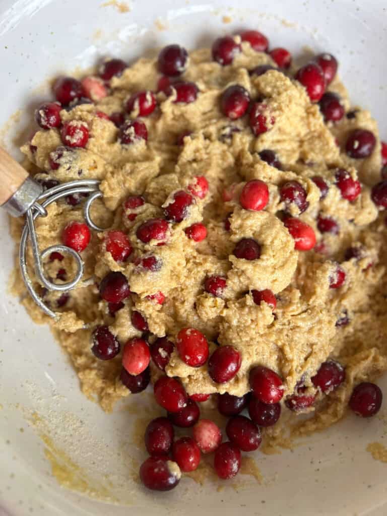 the batter to make fresh milled orange cranberry loaf in a white bowl
