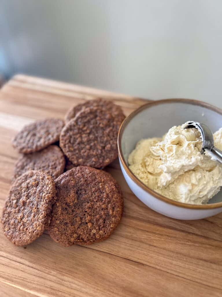 gingerbread oatmeal cookies on a board with white icing in a bowl