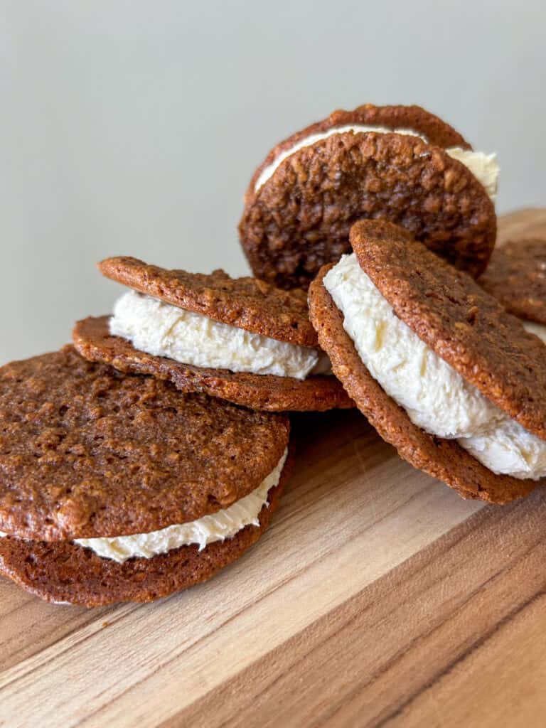 Freshly Milled Chewy Gingerbread Oatmeal Cream Pies stuffed with icing leaning on top of each other