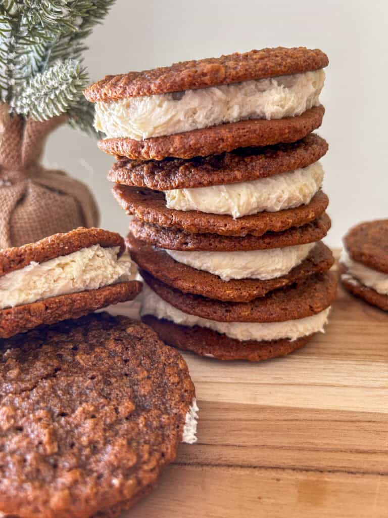 Freshly Milled Chewy Gingerbread Oatmeal Cream Pies stacked on each other on a wooden board