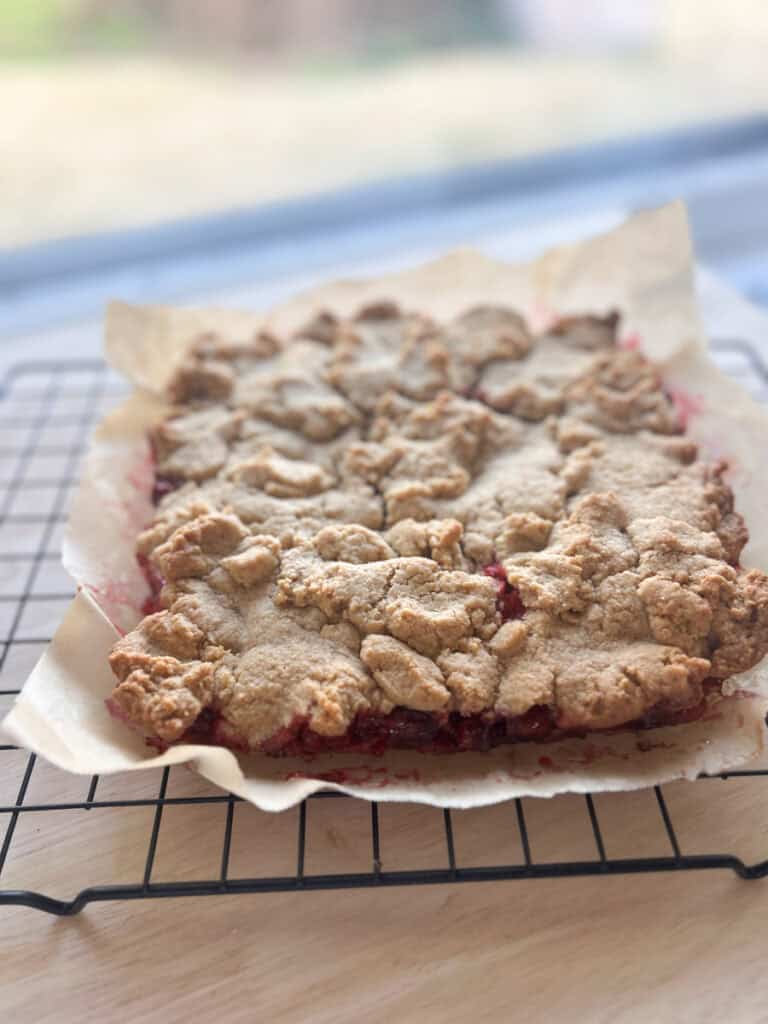 Fresh Milled Cranberry Crumble Bars  cooling on a wire rack with parchment paper