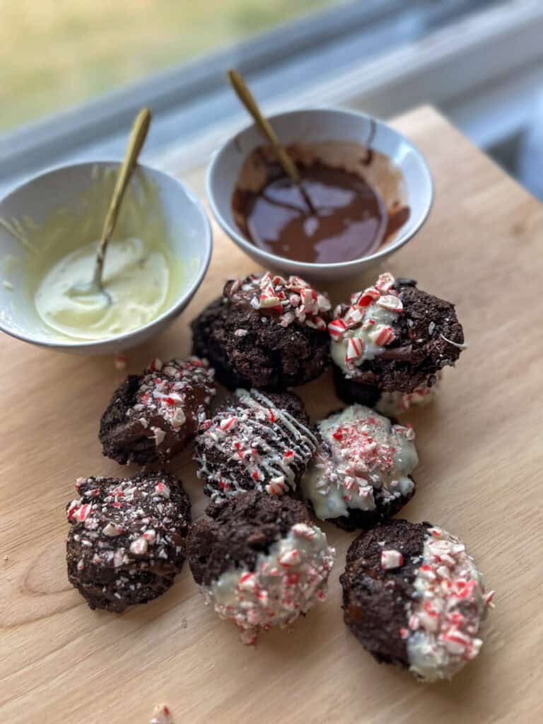 fresh milled double chocolate peppermint cookies on a table with bowls of melted chocolate