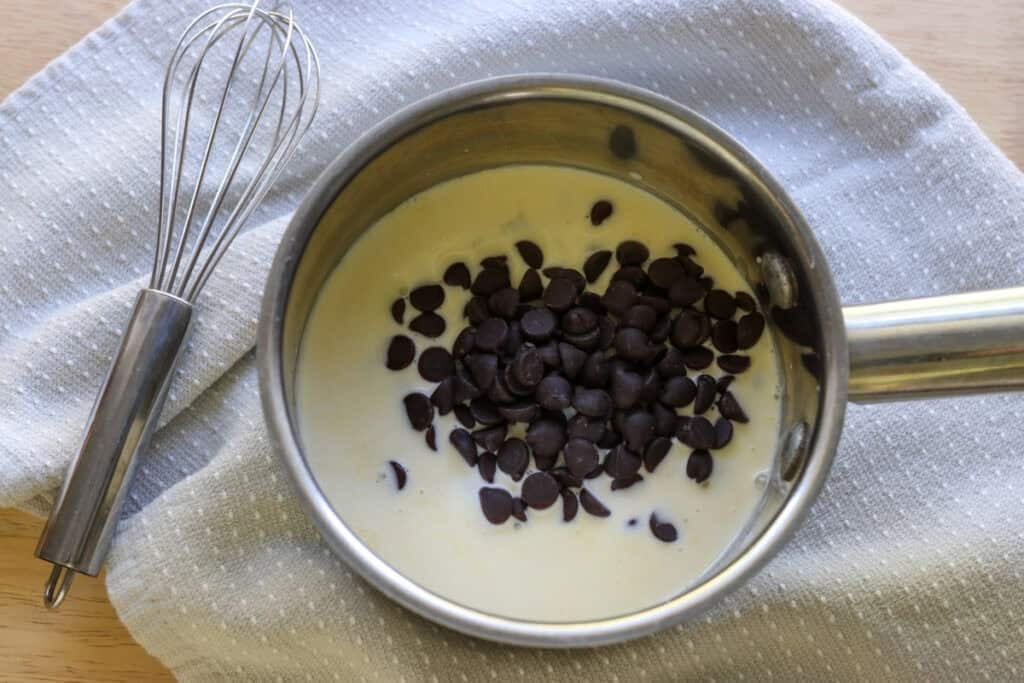 chocolate chips and heavy cream in a saucepan to make Fresh Milled Hot Cocoa Cupcakes with Ganache Filling