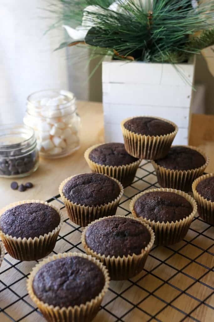 Fresh Milled Hot Cocoa Cupcakes stacked together on a cooling rack with marshmallows 
