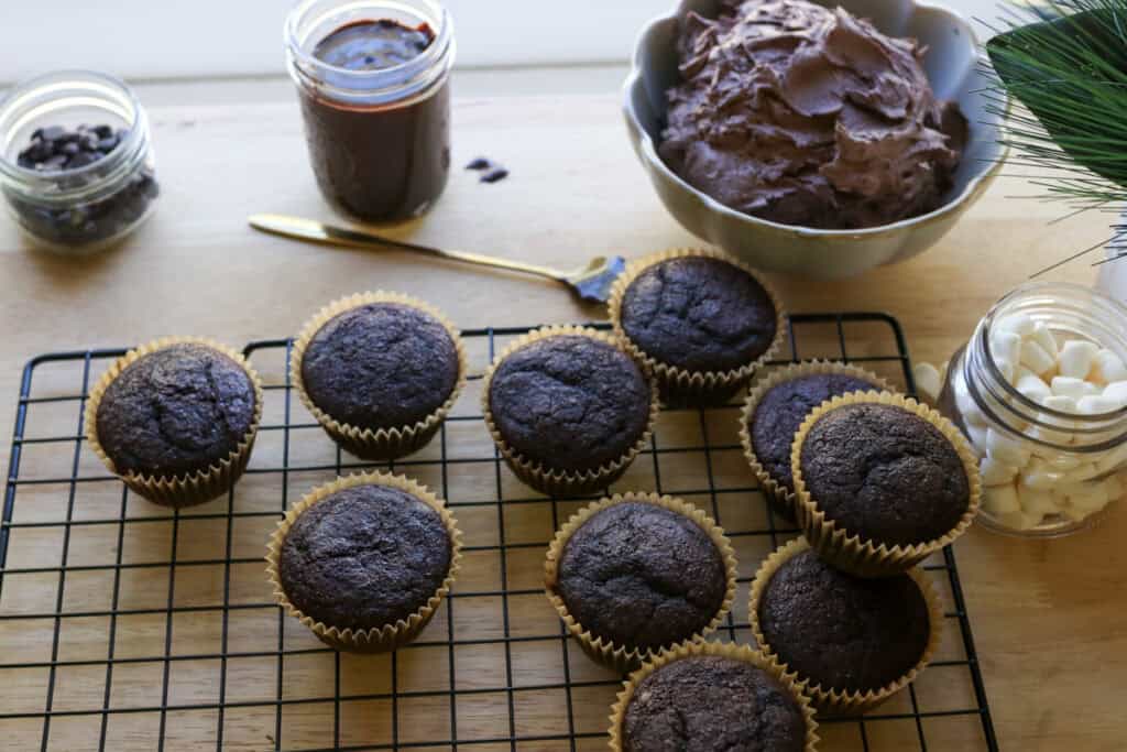 Fresh Milled Hot Cocoa Cupcakes  on a cooling rack with chocolate buttercream and ganache filling