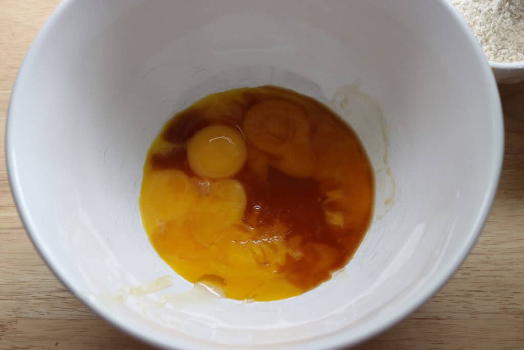 egg yolks and honey in a bowl to make freshly milled chocolate yule log cake