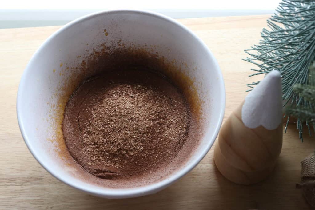 flour and cocoa added to a bowl of egg yolks to make  freshly milled chocolate yule log cake