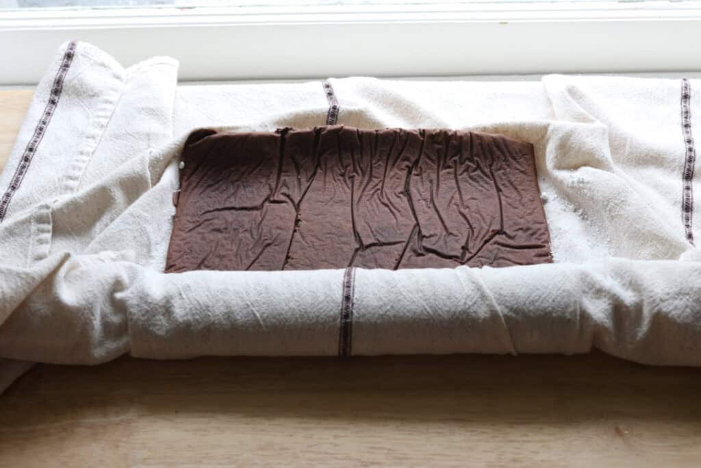  freshly milled chocolate yule log cake that has been rolled in a tea towel