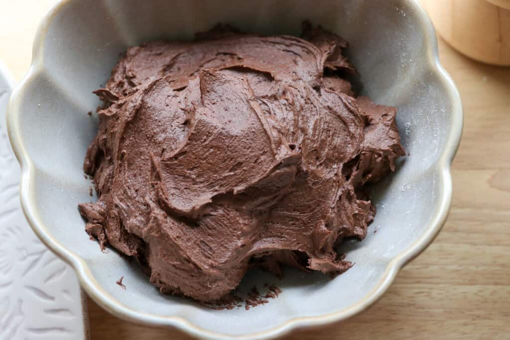 chocolate buttercream in a bowl to spread over the freshly milled chocolate yule log cake