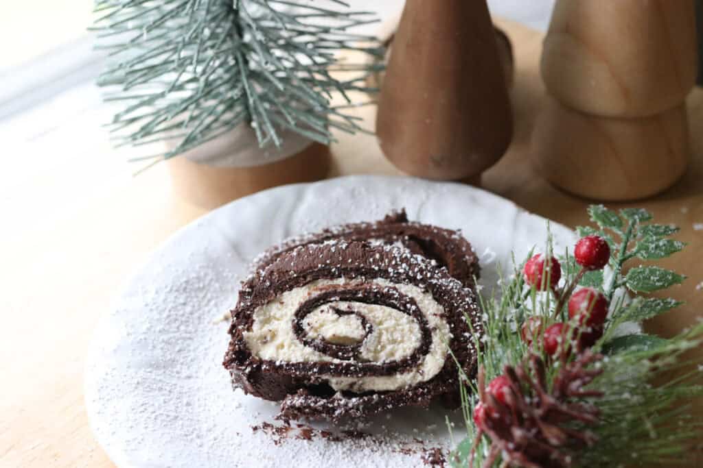 two slices of freshly milled chocolate yule log cake on a white plate