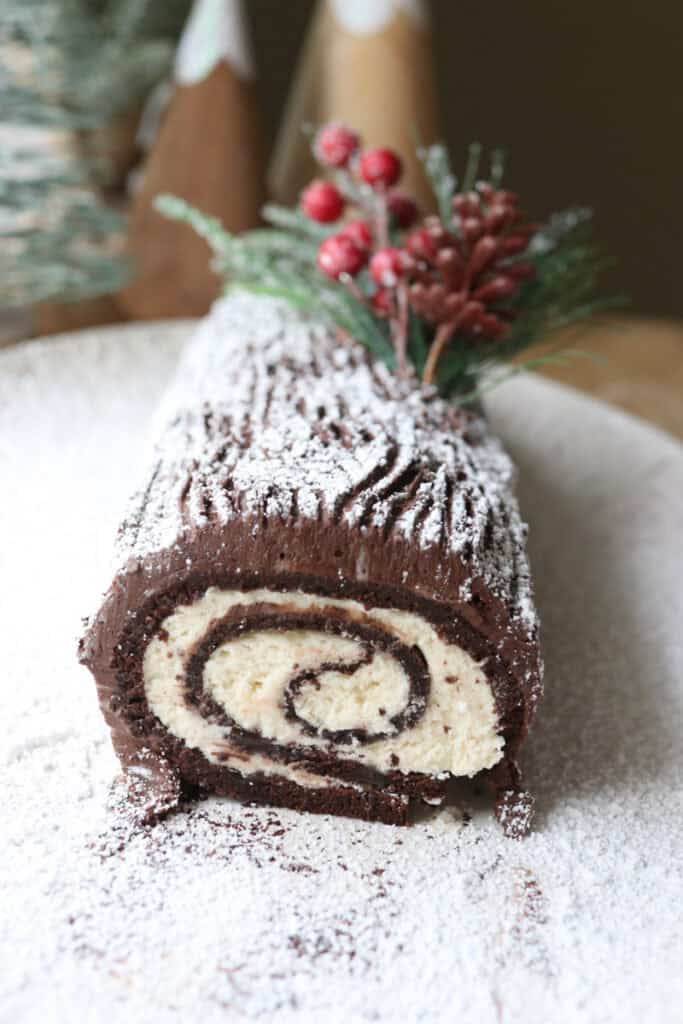 freshly milled chocolate yule log cake with whipped cream filling and powdered sugar