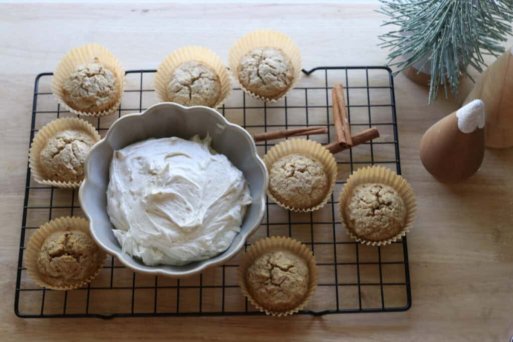 Fresh Milled Eggnog Cupcakes on a wire rack with Cream Cheese Icing in a bowl