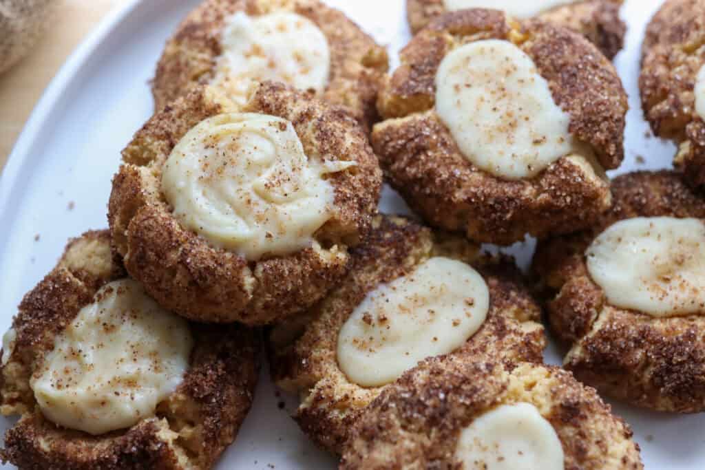 fresh milled eggnog snickerdoodle thumbprint cookies with nutmeg on top on a white plate