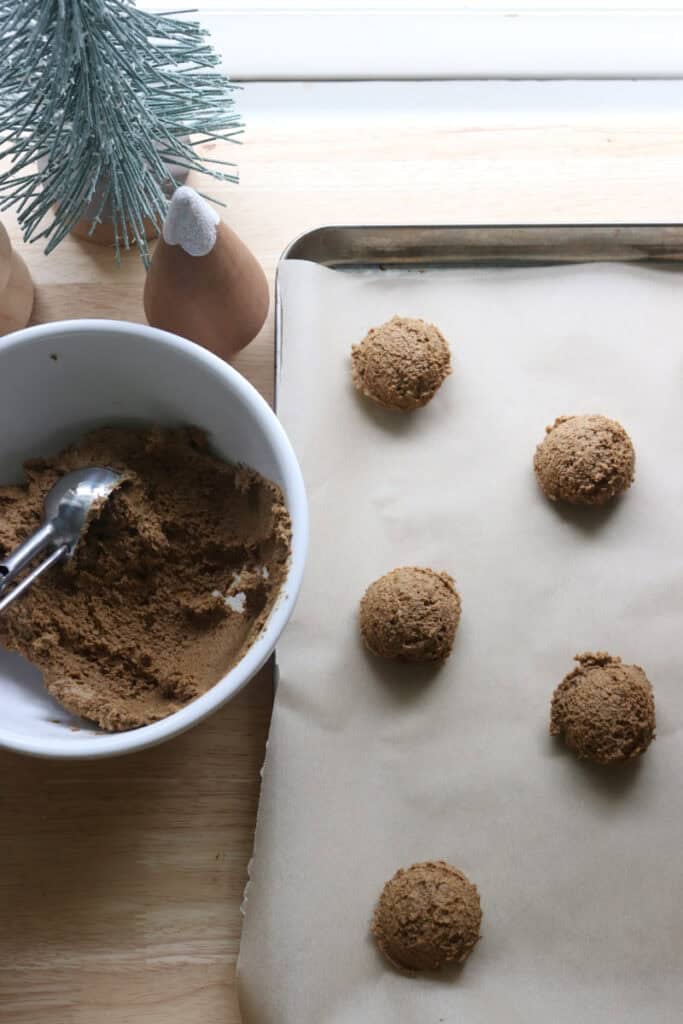fresh milled gingerbread cookie dough that has been scooped and put on a baking sheet