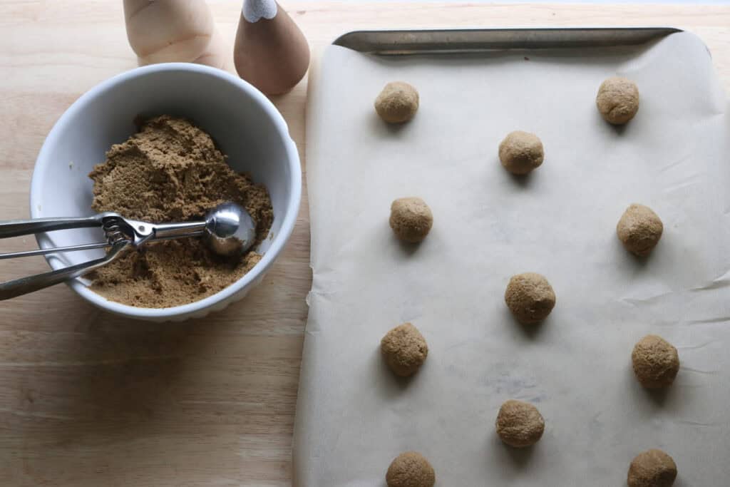 freshly milled gingerbread crinkle cookie dough rolled into balls on a cookie sheet