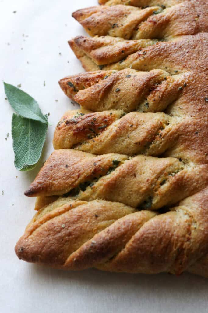 the branches of Fresh Milled Christmas Tree Garlic and Herb Bread with sage leaves