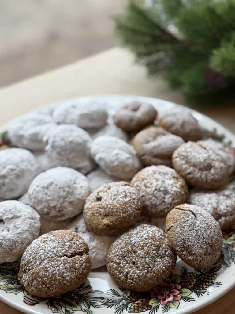 a bunch of German Pfeffernusse Cookies with Fresh Milled Flour on a plate and topped with powdered sugar