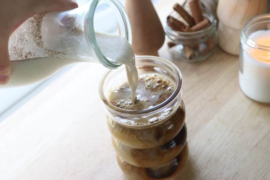 pouring Delicious Healthier Teddy Graham Coffee Creamer into a glass of espresso