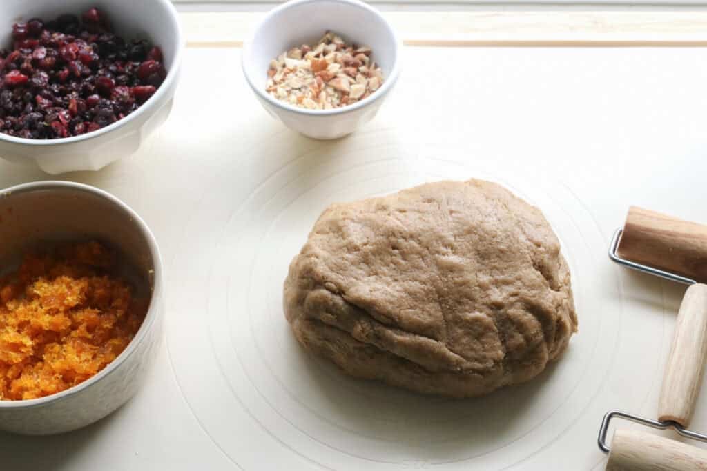 fresh milled Christmas Stollen dough on a mat with a rolling pin