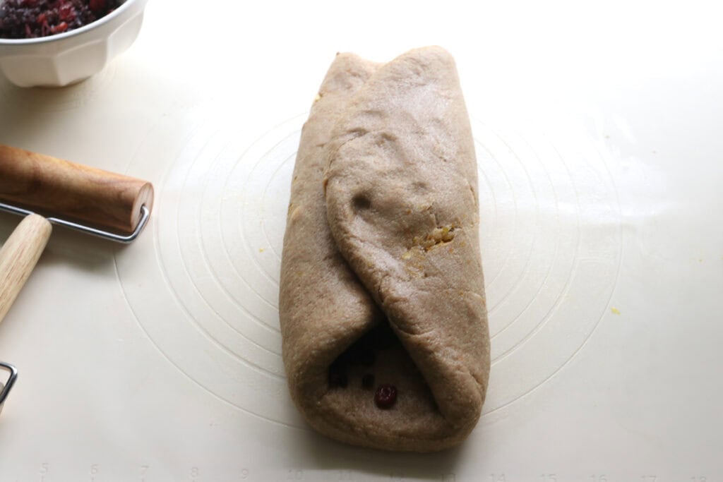 fresh milled Christmas Stollen dough with berries inside and folded up together