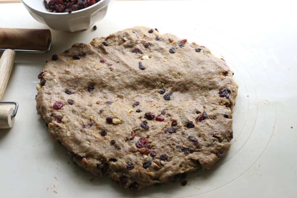 fresh milled Christmas Stollen dough with cranberries and currant in it and an indention in the middle