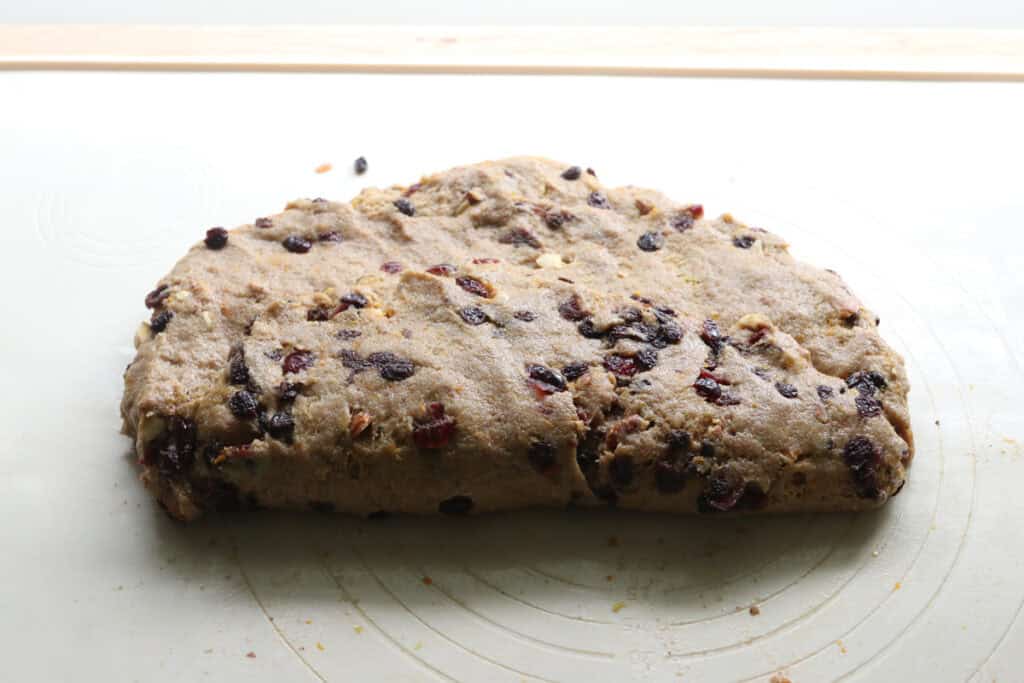 fresh milled Christmas Stollen bread dough folded in half and covered with dried fruits
