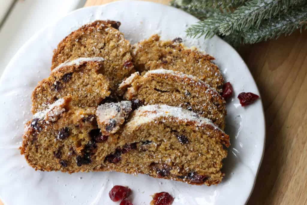 fresh milled Christmas Stollen bread cut into slices on a white plate
