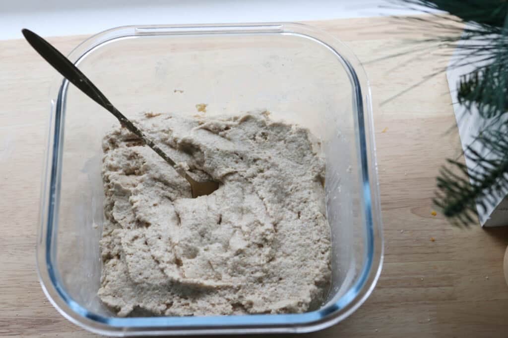 ingredients for the sponge to make fresh milled panettones in a glass container with a spoon