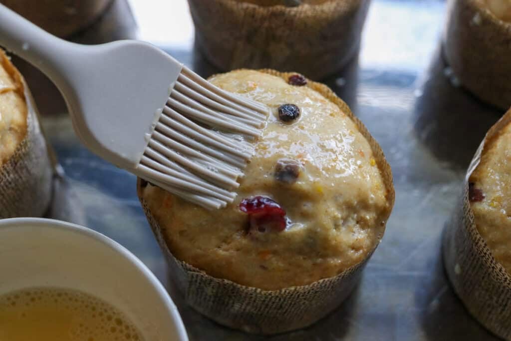 brushing the homemade fresh milled mini panettones with an egg wash