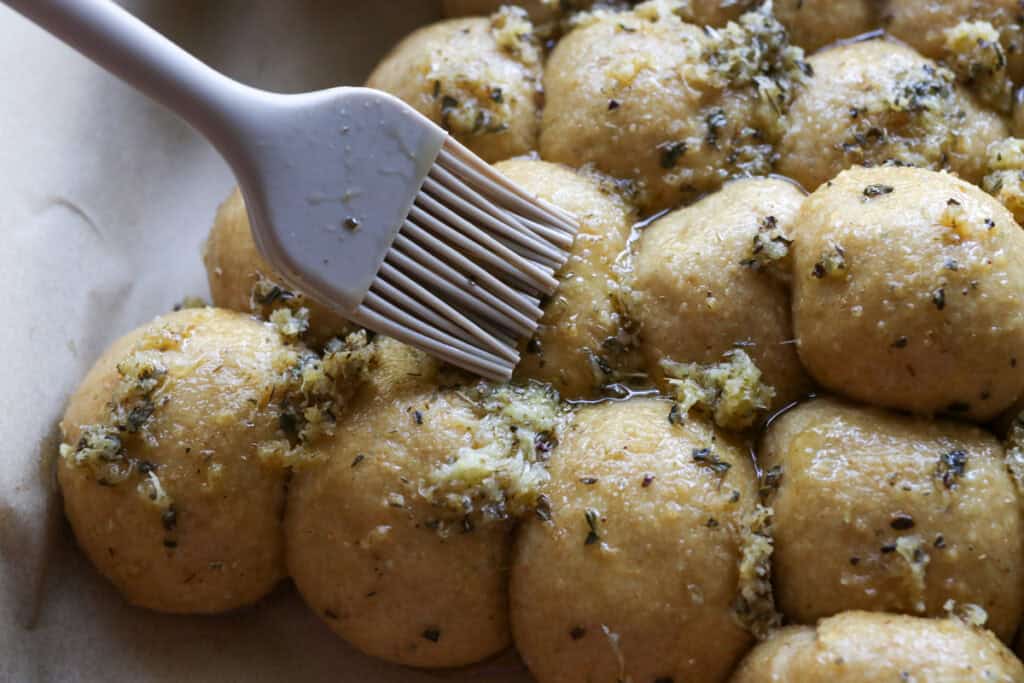 brushing garlic butter onto Fresh Milled Cheesy Pull-Apart Christmas Tree Bread