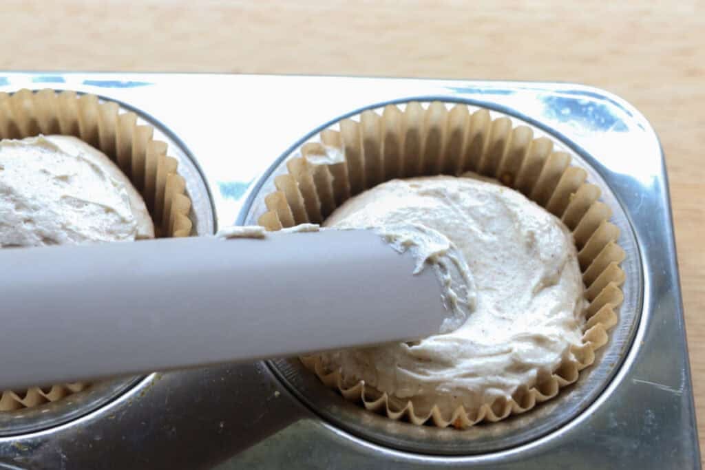 spreading out the cheesecake filing for No-Bake Mini Christmas Gingerbread Cheesecake Cups