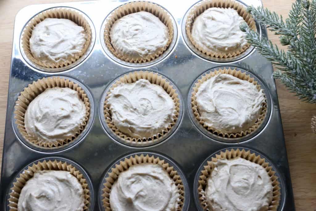 No-Bake Mini Christmas Gingerbread Cheesecake Cups in a stainless steel muffin pan