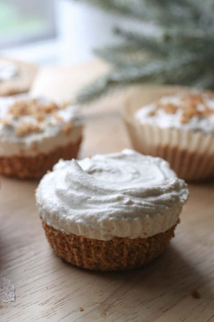 a No-Bake Mini Christmas Gingerbread Cheesecake Cup with a graham cracker base on the bottom