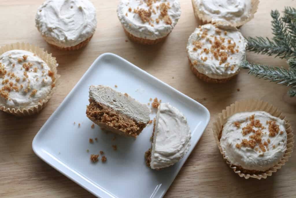 No-Bake Mini Christmas Gingerbread Cheesecake Cups with one cut in half on a plate