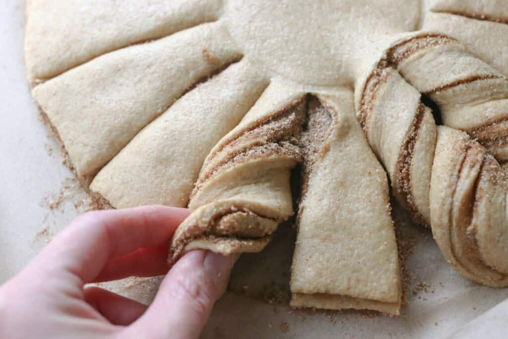 fresh milled cinnamon sugar star bread that is being twisted to make a star shape