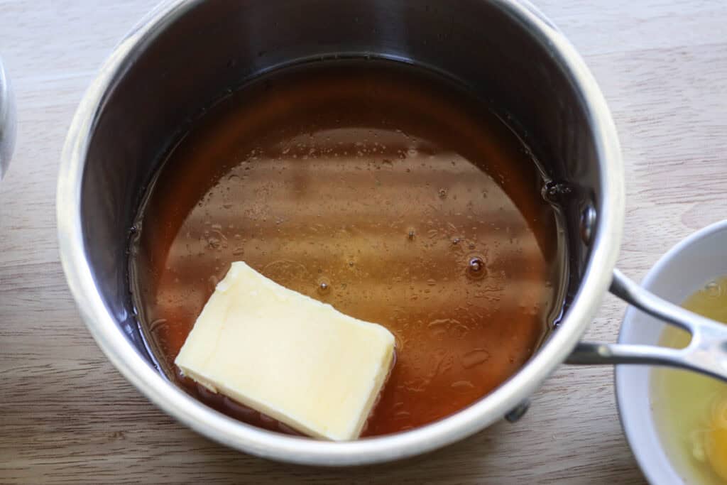 apple cider and butter in a pan to make fresh milled apple cider donuts