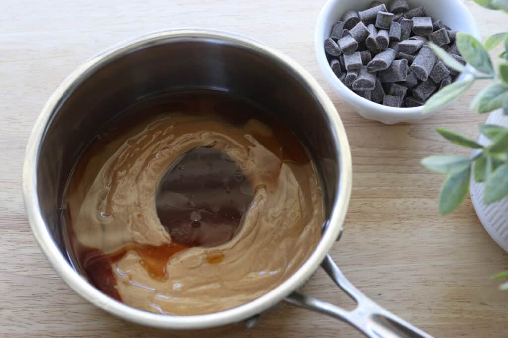 peanut butter and maple syrup in a pot to make Chocolate Peanut Butter Rice Krispie Bars