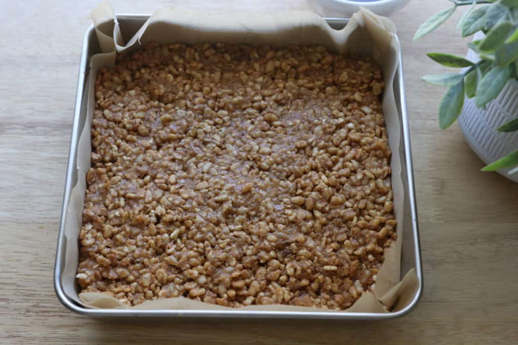 rice krispie mixture pressed into a pan to make Chocolate Peanut Butter Rice Krispie Bars